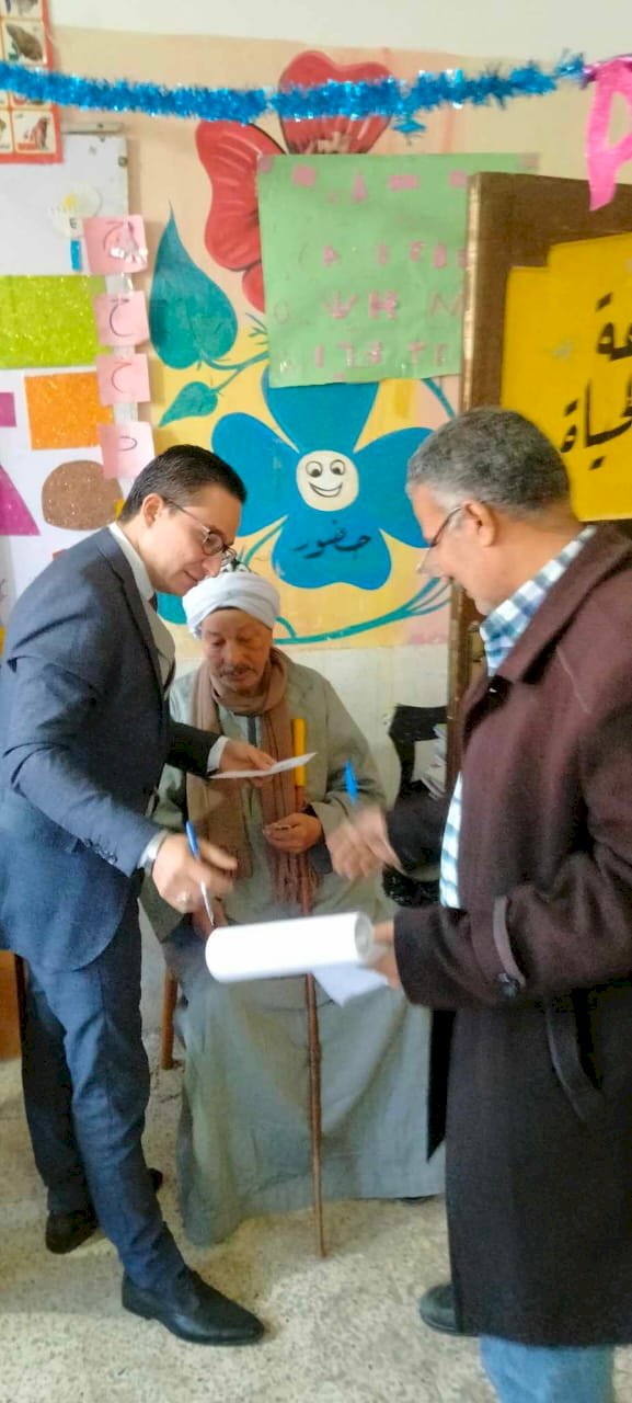 قاضي يخرج من اللجنة لمساعدة مسن في الإدلاء بصوته ببني سويف